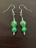 Silver tone fish hook earrings with green floral clay, green rhinestone rondelle, and green glass pearl beads. 